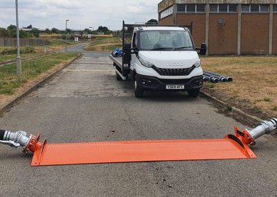 Treatment Sewage Work set up on site. Van on site off-loading pipe work, set up behind 2 pips that have been connected by an orange ramp.