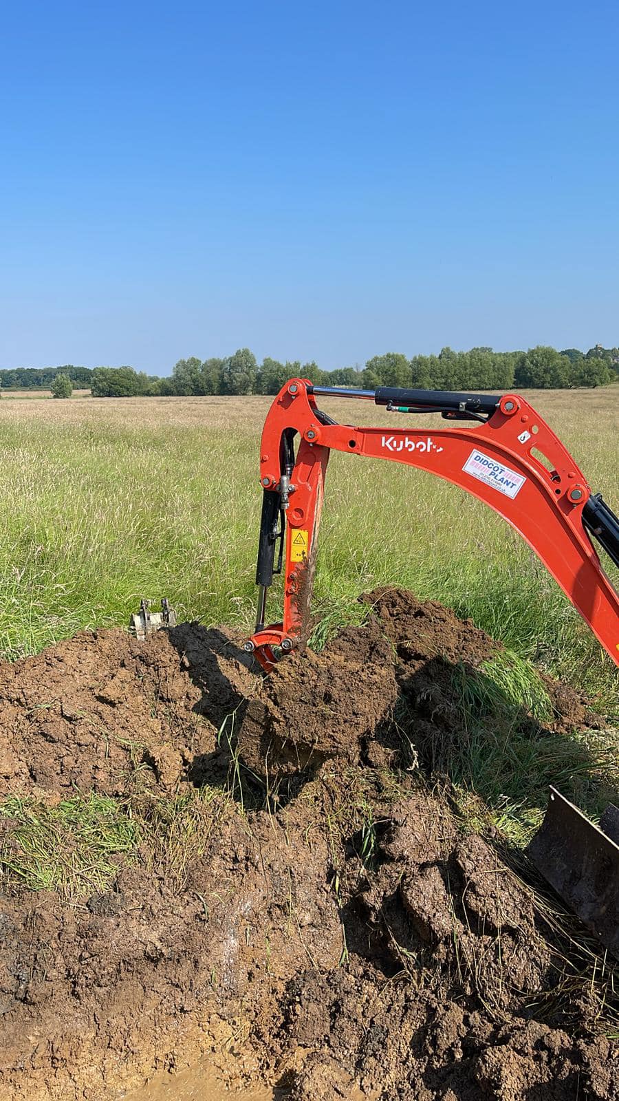 Machinery digging into field on a sunny day