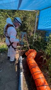 Person in protective gear overseeing drain project