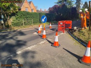 Orange traffic cones blocking off a lane turning into a road