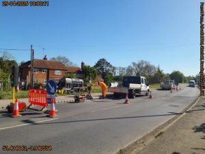 Road works taking place inside a closed lane in a road separated by traffic cones