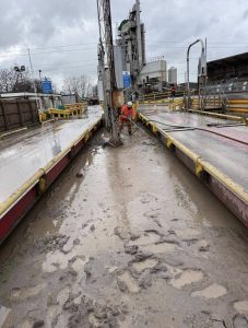 Drain Technology worker pumping away dirt under a weighbridge
