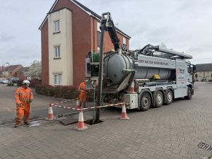 Drain Technology truck and workers pumping underground on an housing estate 