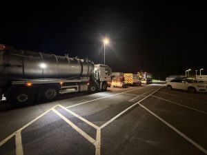 Drain Technology vehicles parked on a road in the dark