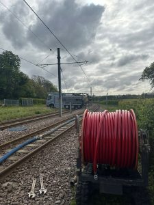 Rail track with reel of cable on the verge
