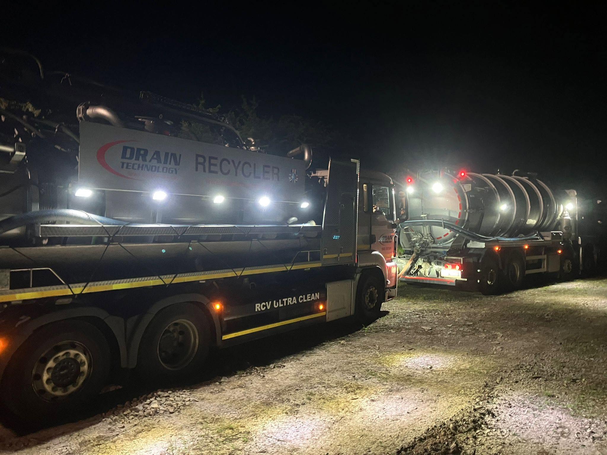 Two Drain Tech tankers in the dark