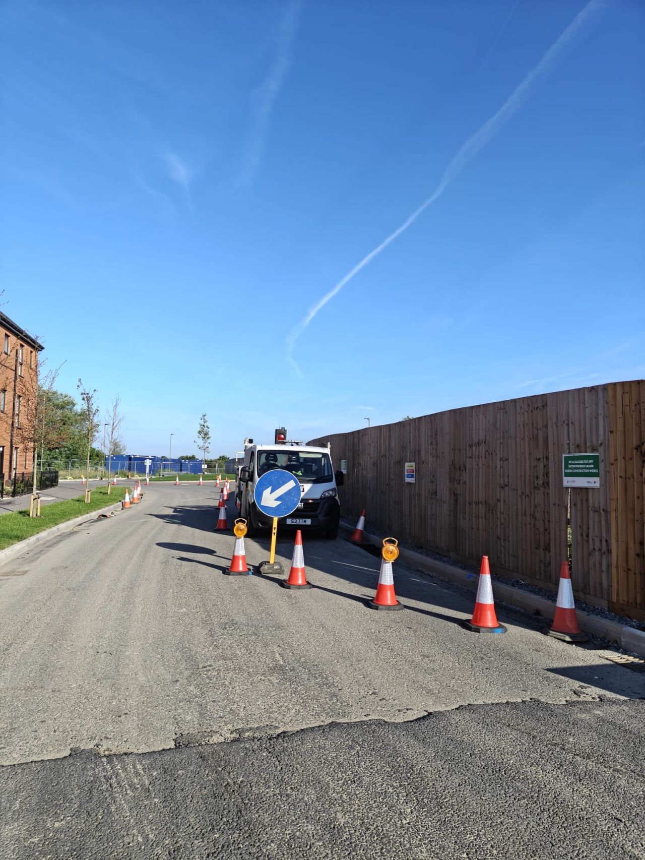 Bright blue sky with traffic cones lining a pathway