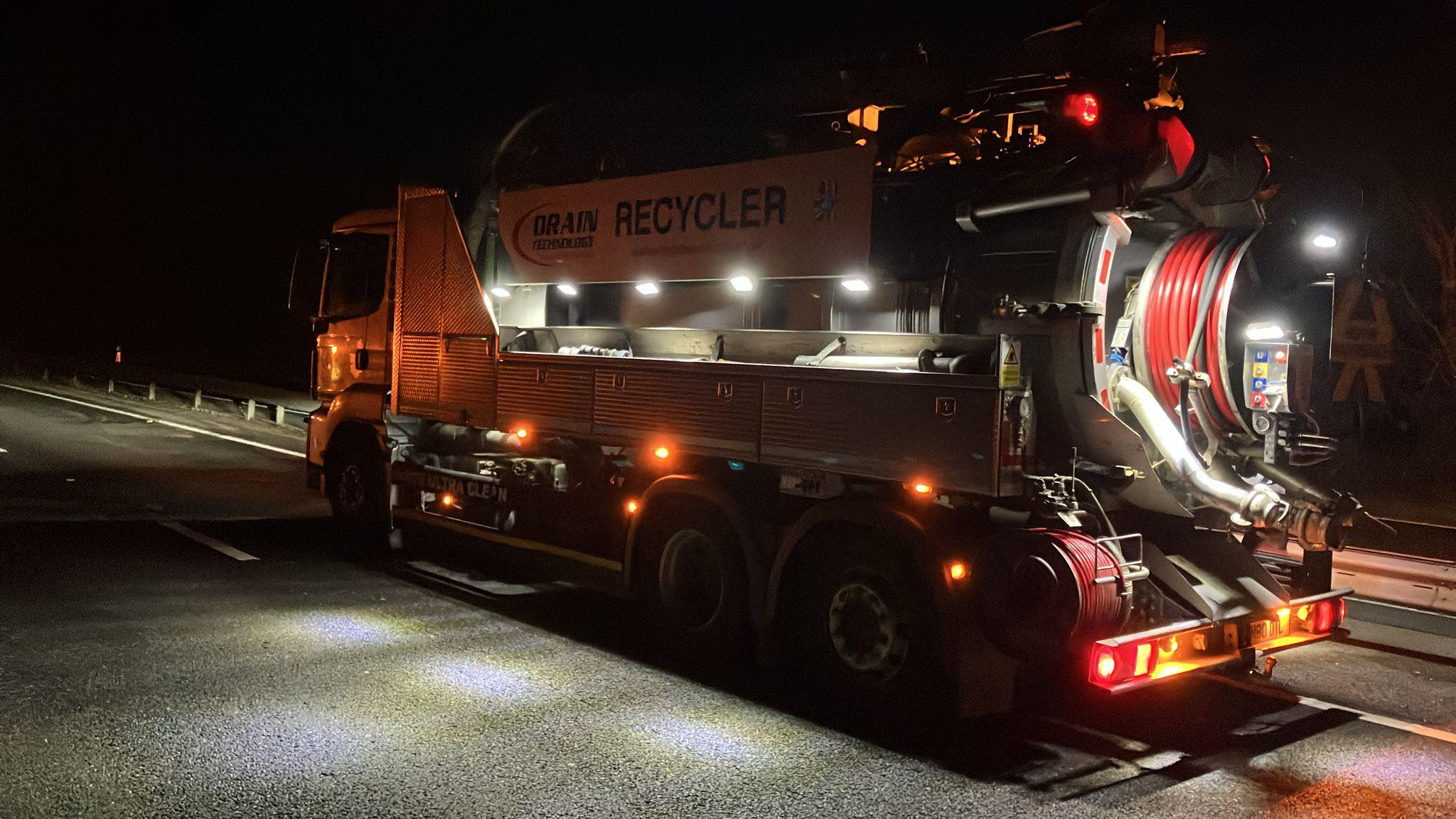 Drain Technology tanker on the side of a road at night time