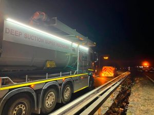 Drain technology tanker on the side of the road at night