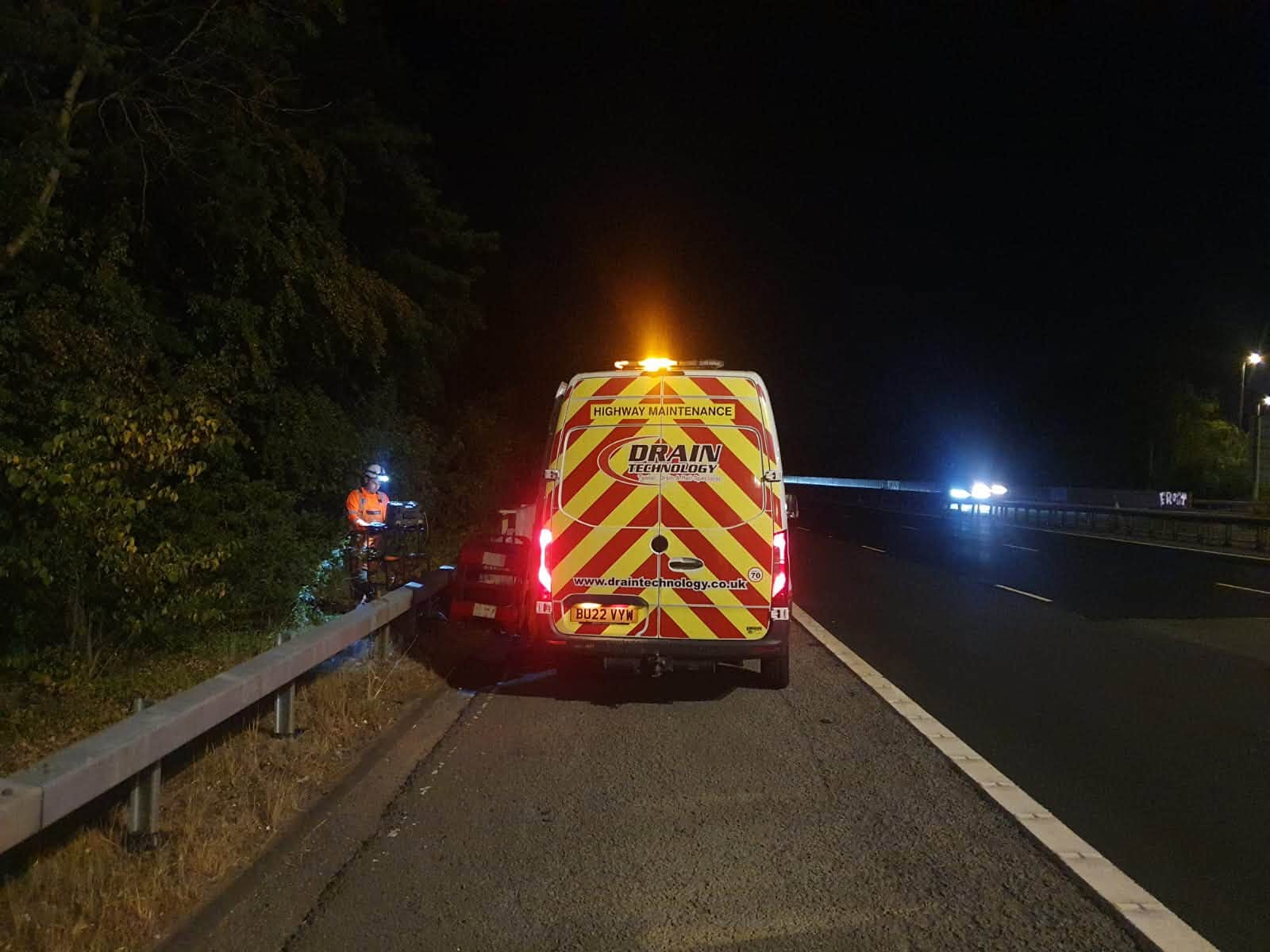 Drain tech striped van on the side of a dark road