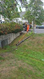 worker feeding piooes down to a big pipe in a wall