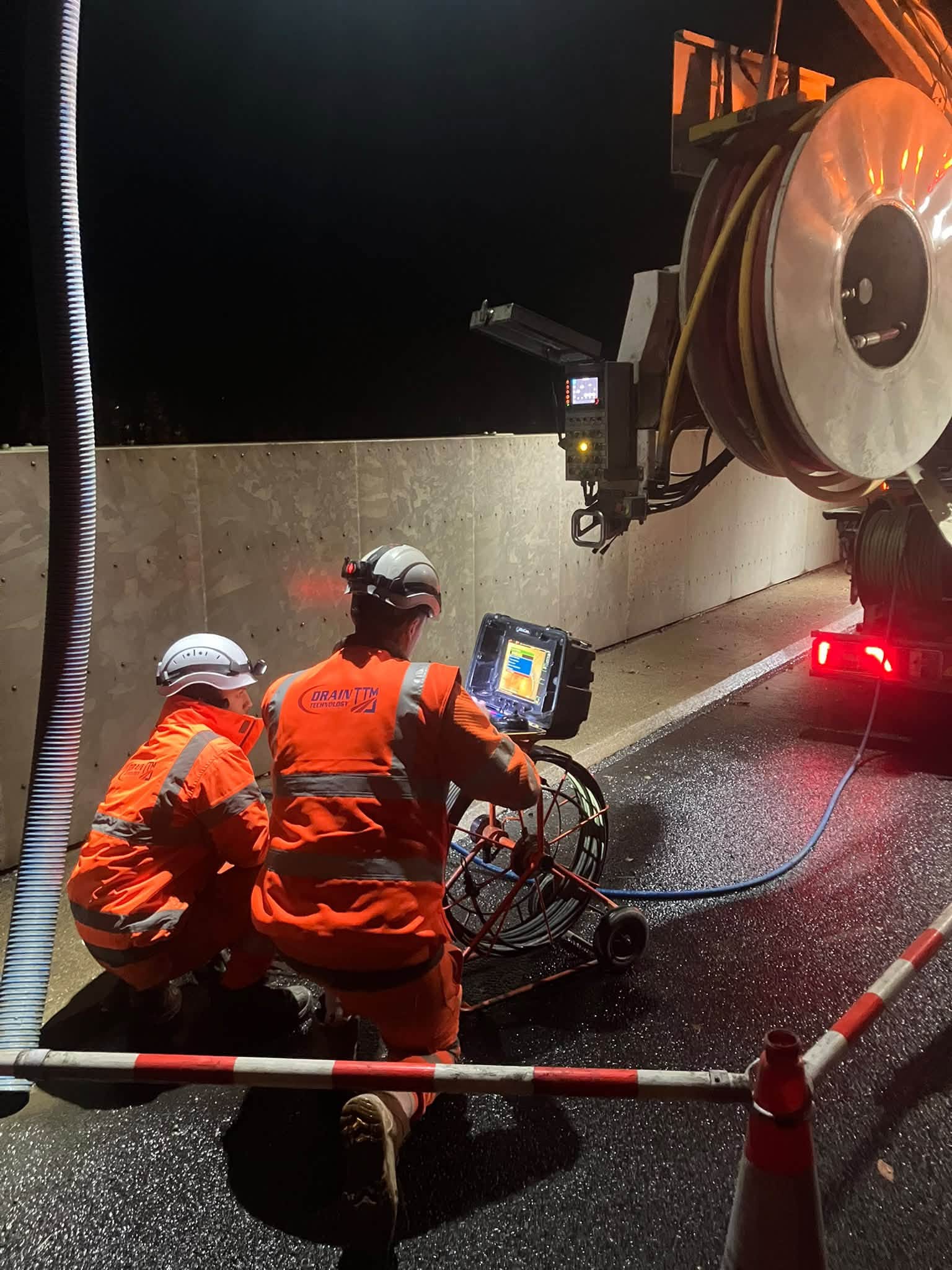 DT News 22:10 2 two workers using equipment next to a tanker in the dark