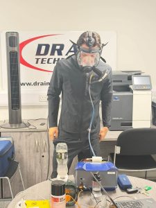 man in black jacket wearing a face mask in a test in an office