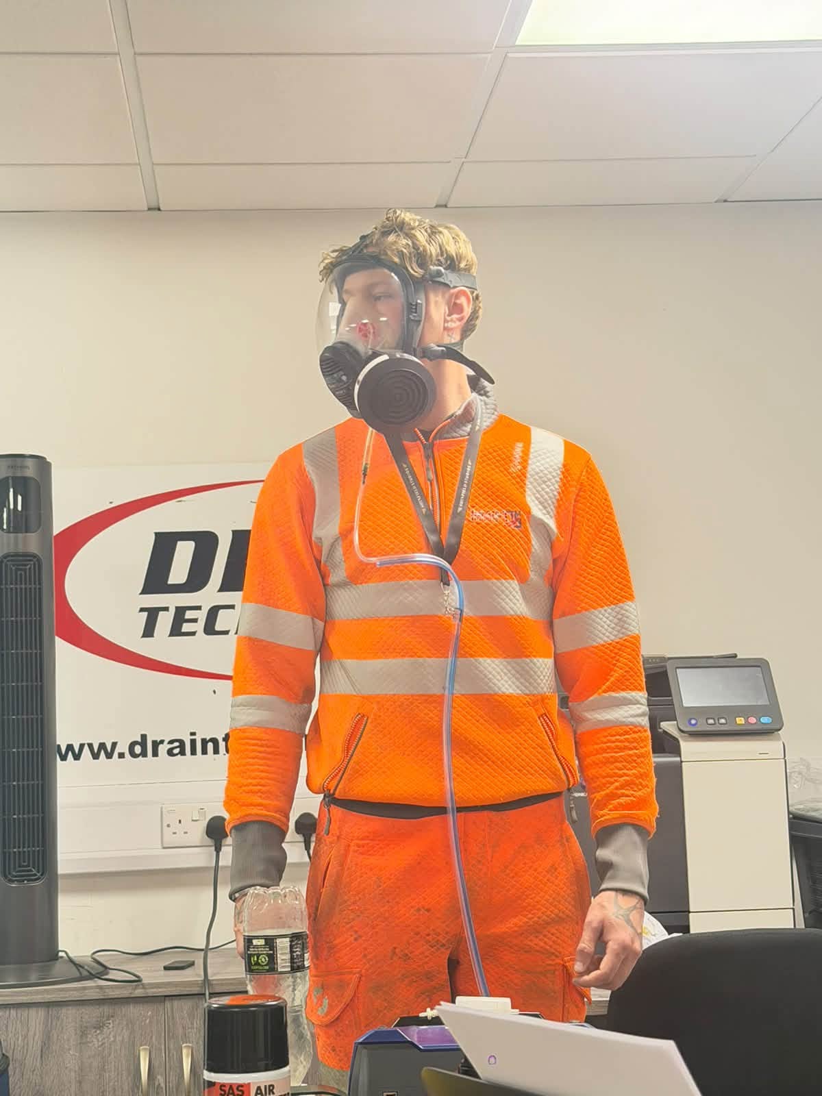 man in orange workwear wearing a face mask in a test in an office