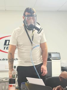 man in white t shirt wearing a face mask in a test in an office