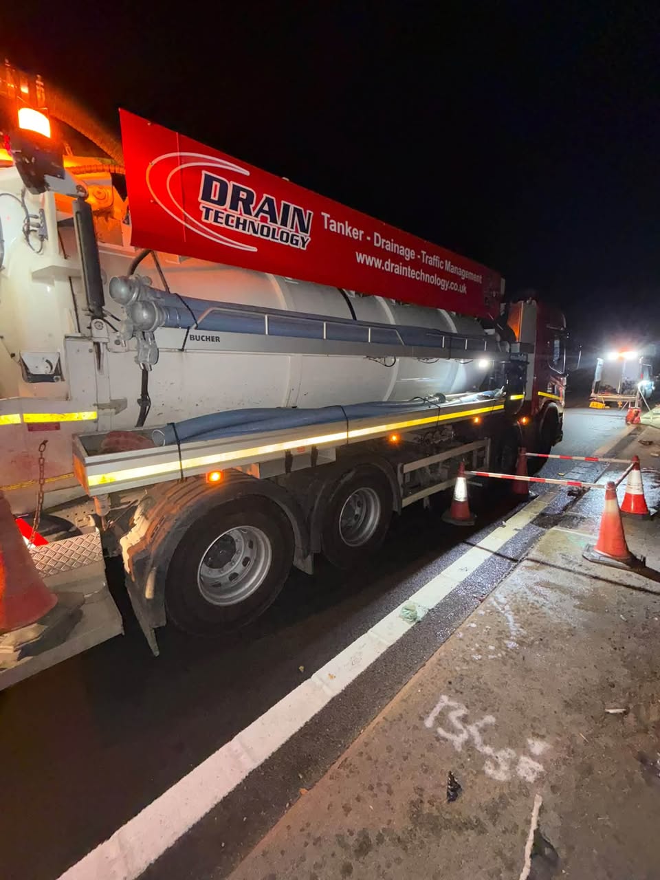 Drain Technology tanker on the side of the road at night